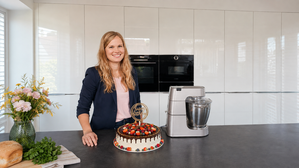 Porträt der Gründerin von Lena’s Cake Art in moderner Küche mit Schokoladentorte und Küchenmaschine.