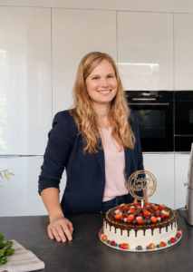 Lena, Gründerin von Lenas Cake Art, in ihrer Küche mit Küchenmaschine und dekorierter Geburtstagstorte